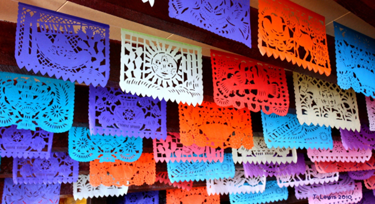 A selection of colorful papel picados, pieces of paper that have been transformed to works of art