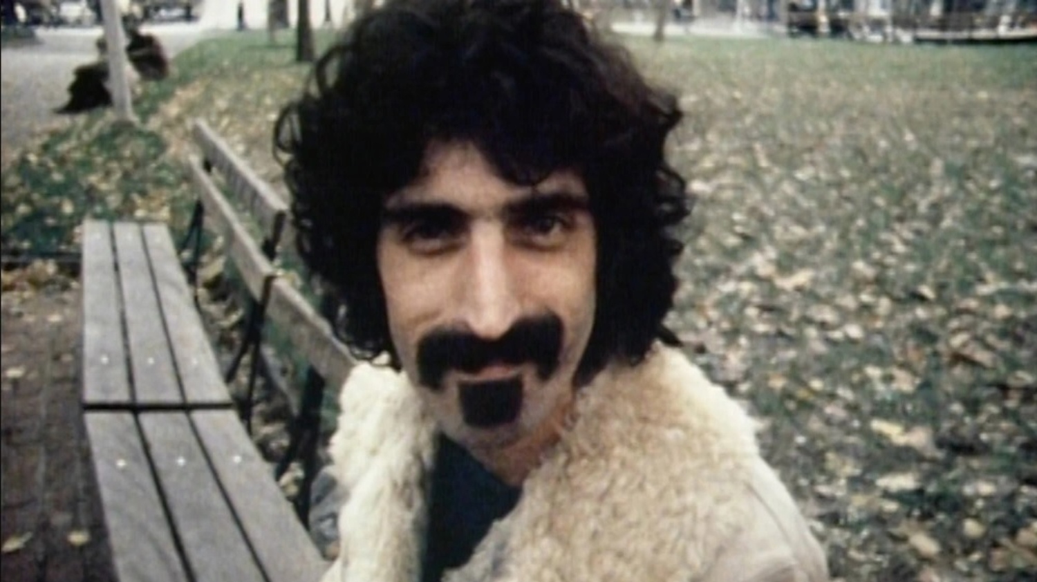 Frank Zappa sitting on a bench