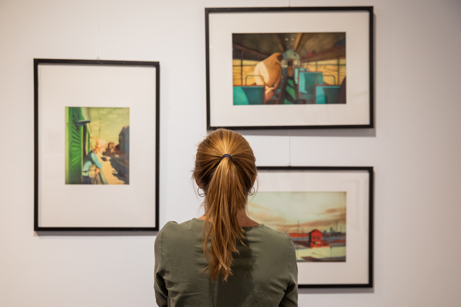 A person is looking at art from the Le Immagini Della Fantasia 2021 collection at the illustradays Athens festival